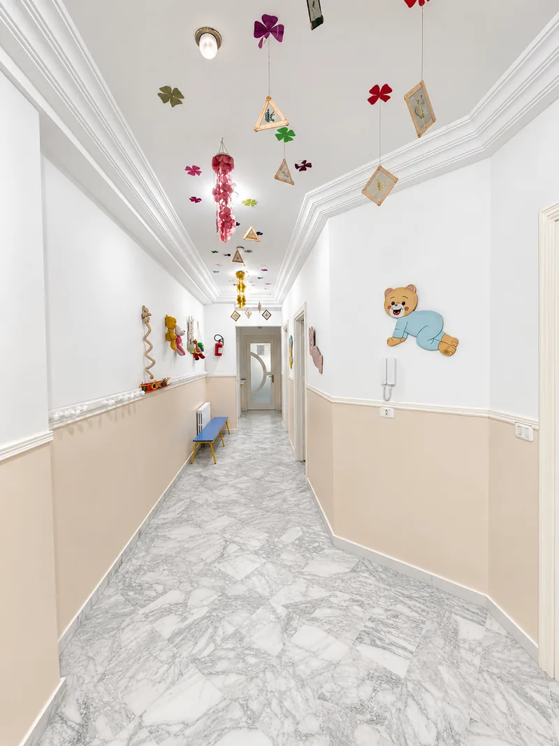 Le couloir de l'école : sol en marbre et décorations suspendues réalisées par les enfants